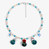 Close-up of a handmade Swarovski crystal charm necklace with crystals, pearls and travel-inspired collectible charm details