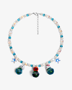 Close-up of a handmade Swarovski crystal charm necklace with crystals, pearls and travel-inspired collectible charm details