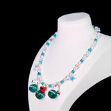 Model wearing a handmade Swarovski crystal charm necklace with crystals, pearls and travel-inspired collectible charm details