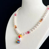 Close-up of a handmade Swarovski crystal charm necklace with crystals, pearls and western-inspired collectible charm details