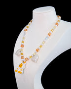 Model wearing handmade amber crystal charm necklace with Swarovski pearls and vintage pendant