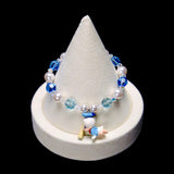 Deep blue and pale aqua crystal rounds alternate with white pearl beads and clear spacers, framing a little Donald Duck charm in a light blue sailor outfit.