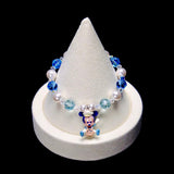 Blue and pale aqua crystal rounds, white pearl beads and clear spacers frame a little Mickey Mouse charm wearing a captain's hat and holding a ship's wheel.