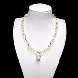 Pale yellow crystal cubes alternate with clear iridescent rounds. Two yellow stars frame a Hello Kitty charm in a white outfit with gold-colored details.