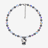 Necklace with dark gray Swarovski crystal pearls, iridescent crystal cubes and a cat charm in a black bonnet outfit with white trim.
