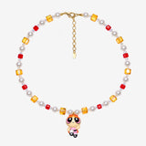Necklace with red and amber Swarovski crystals, white crystal pearls and an orange-haired girl charm wearing a red bow and pink dress.