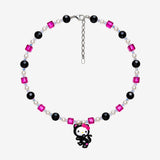Necklace with fuchsia and black Swarovski crystals, white crystal pearls and a white-faced character charm in a black cat costume with a pink bow.