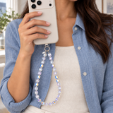 Woman in a blue shirt holding an ivory phone with an Aurora iridescent crystal phone chain.