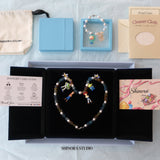 Gift-ready ShinoraStudio packaging for a handmade red Swarovski crystal charm necklace with retro-inspired collectible charm details