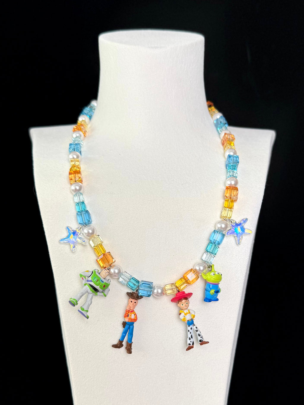 Handmade Toy Story charm necklace on jewelry display - Y2K coquette aesthetic with Swarovski crystals